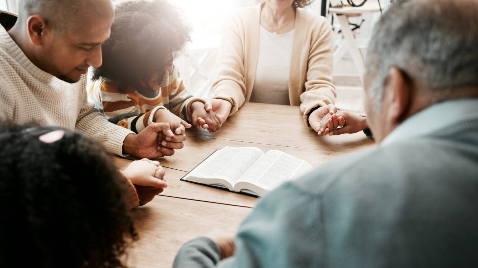 hands together praying at a table